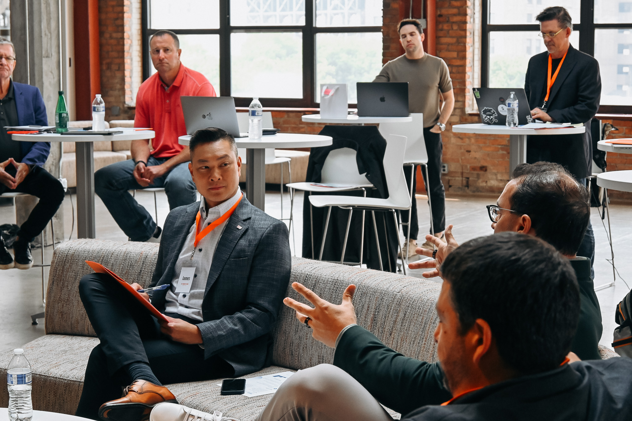 Group of people sitting around couches and tables having discussions